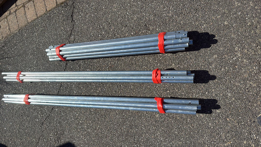 Galvaniserte metallrør buntet sammen med røde Simple Strap stropper.